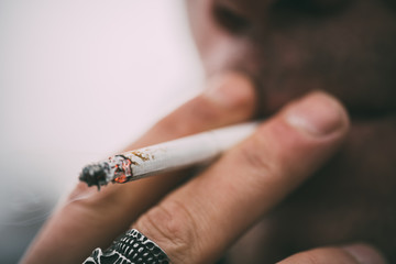 A man smokes a cigarette. Guy with glasses smokes cigarettes. Tobacco smoke