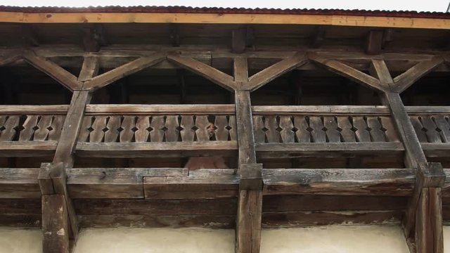 frame from below young girl stand on wooden balcony look around serious beautiful look model mood move nature palac castle playful positive street ancient architecture outdoor close up