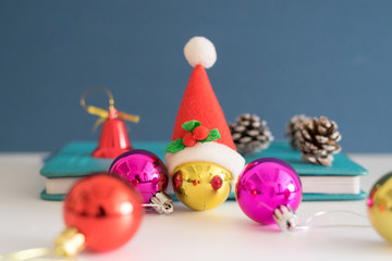Christmas concept with copy space.Ornament balls, Santa Claus hat and note book with blue background.