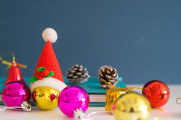 Christmas concept with copy space.Ornament balls, Santa Claus hat and note book with blue background.