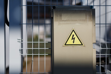 Gray hinged power supply, electric flap. Danger sign with dangerous voltage