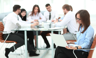 Executive businesswoman with laptop on blurred background business team