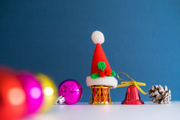 Christmas Concept with copy space.Small Santa Claus hat with ornament balls,bell,pineconse and small present.