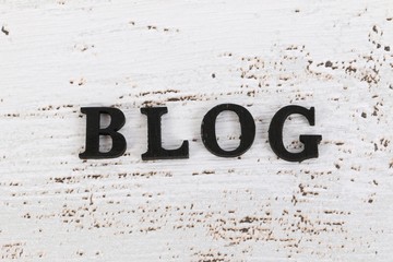 black wooden letters lying in a row on the table and describe the word blog