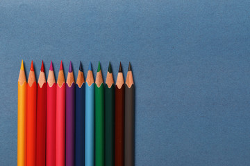 Multicolored pencils lie on a blue background