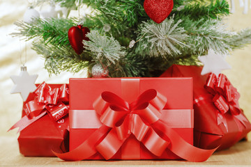 Close-up. Under the Christmas tree, decorated with toys are red boxes with gifts