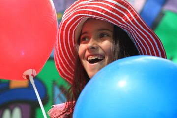 Girl playing with balloons in the park. Birthday.