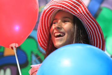 Girl playing with balloons in the park. Birthday.