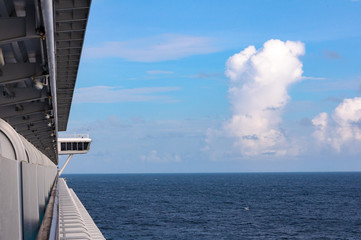 View of Cumulus clouds over the ocean from the deck of a cruise ship.