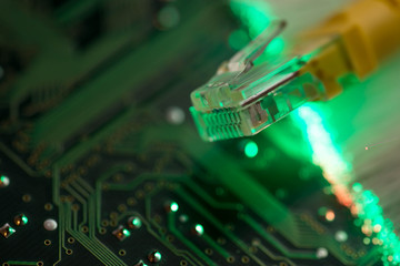 Yellow internet switch, glowing optical fibres on computer circuit board, space for text.