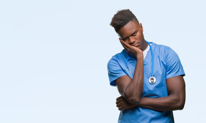 Young african american doctor man over isolated background wearing surgeon uniform thinking looking tired and bored with depression problems with crossed arms.