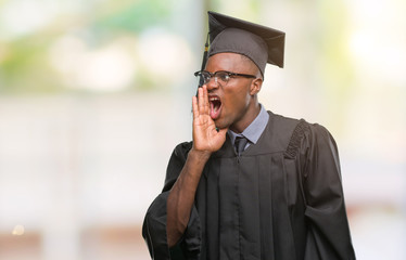 Young graduated african american man over isolated background shouting and screaming loud to side with hand on mouth. Communication concept.