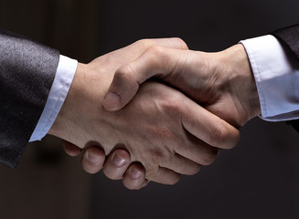 close up.handshake of business partners on a dark background