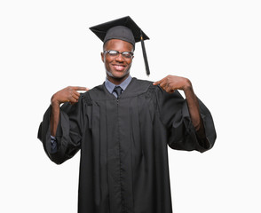 Young graduated african american man over isolated background looking confident with smile on face, pointing oneself with fingers proud and happy.