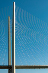 Supports suspension bridge with a web of ropes against the blue sky