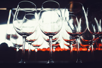 Many empty wine glasses in a restaurant on dark background