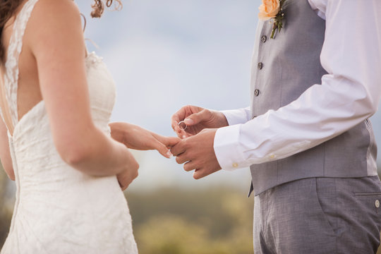 Groom Putting Wedding Ring On His Bride