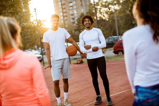 Group of multiethnic people  playing basketball on court
