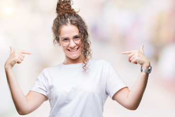 Beautiful young brunette curly hair girl wearing glasses over isolated background looking confident...