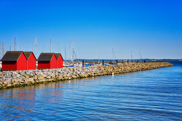 Red fisher houses behind the stone groyne at the harbor Wei?e Wiek in Boltenhagen at the Baltic...