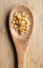 Pine nuts on wood spoon.