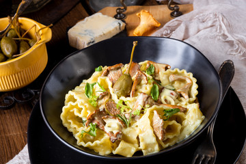 Reginette noodles in cream sauce with fresh chanterelles and capers