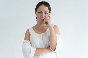 Pensive lovely woman touching face. Young lady looking at camera. Contemplation concept. Isolated front view on white background.