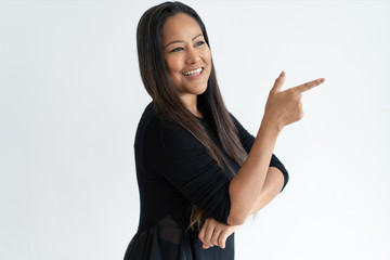 Smiling attractive middle-aged woman pointing aside. Lady looking away and recommending something. Advertisement concept. Isolated view on white background.