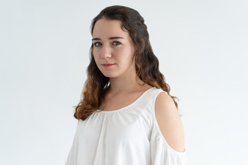 Obraz premium Young lovely woman looking at camera. Wavy-haired lady posing. Beautiful woman portrait concept. Isolated view on white background.
