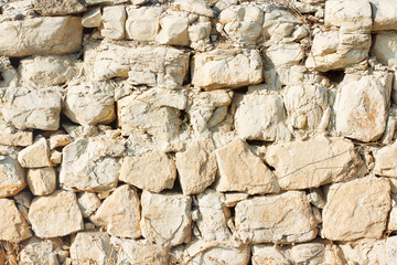 Old desert bricks wall background. Brown stones texture. Bright rocks pattern.