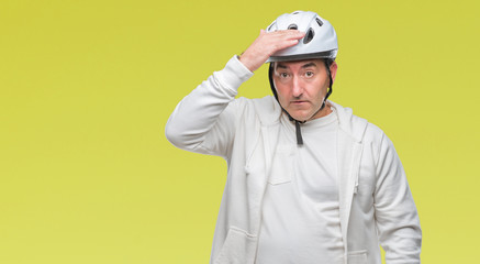 Handsome senior cyclist man wearing bike helmet over isolated background stressed with hand on head, shocked with shame and surprise face, angry and frustrated. Fear and upset for mistake.
