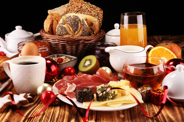 breakfast on table with bread buns, croissants, coffe and juice on christmas day. xmas holiday...
