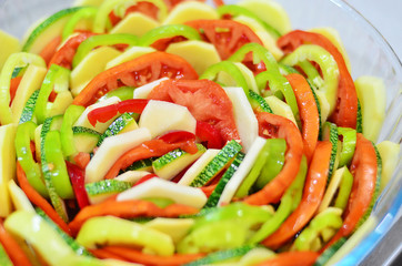 Assorted vegetables. Mixed vegetables. Paradise for vegetarians. Salad of red tomatoes, green cucumbers, green courgettes, red and green pepper. Vegetarian salad in a transparent plate.
