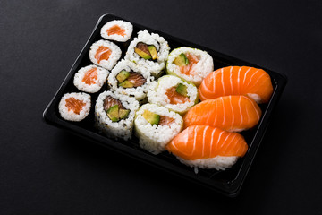 Japanese food: maki and nigiri sushi set on black background. Close up