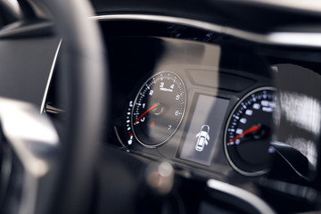 Close-up of a glowing beautiful dashboard of a modern expensive car. The interior of the car. The foreground is blurred