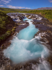 Plakat Braurfossar is amazing waterfall with colorful clouds and blue sky over