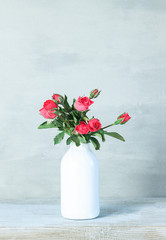 Beautiful pink flowers in vase on gray background with copy space. still life with spring flowers