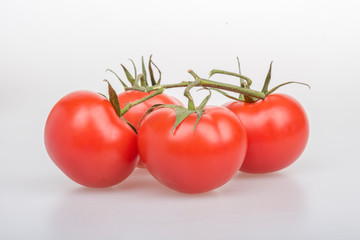 Red tomatoes on a table on a white background