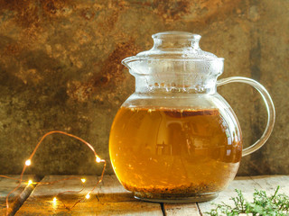 green tea in a transparent teapot on the table (herbal tea is brewed). top view.
