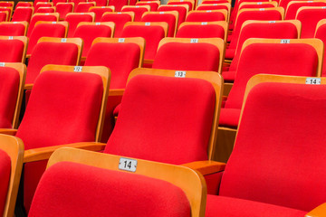 Red chairs in the auditorium of the theater or concert hall.