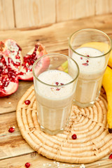 Smoothie with oat or oatmeal, banana and pomegranate on wooden rustic background