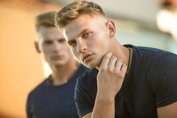 Obraz premium Showing off all the good bits of your body. Fashion twins with fit body. Pair of twins with muscular look. Muscular men in good physique. Athletic men outdoor. Handsome twins in casual fashion style
