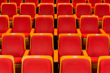 Red chairs in the auditorium of the theater or concert hall.