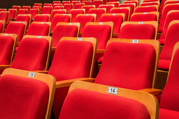 Red chairs in the auditorium of the theater or concert hall.