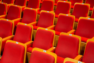 Fototapeta premium Red chairs in the auditorium of the theater or concert hall.
