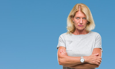 Middle age blonde woman over isolated background skeptic and nervous, disapproving expression on...