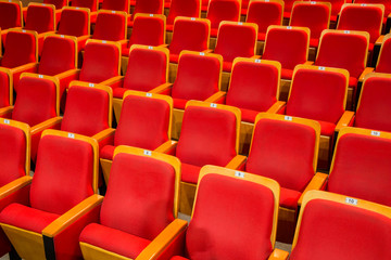 Red chairs in the auditorium of the theater or concert hall.