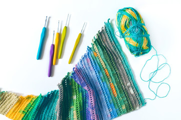 Women's hobby. Bright crochet hooks and ball of yarn on white background.	