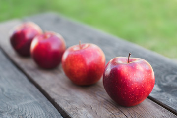 Red apples on a wooden table in autumn