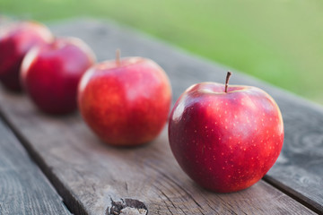 Red apples on a wooden table in autumn